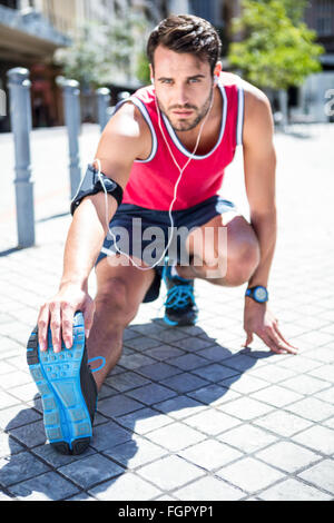 Bello atleta gamba facendo stretching Foto Stock