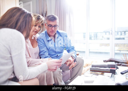 Interior designer con tavoletta digitale in consultazione con coppia Foto Stock