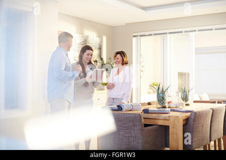 Interior designer con tavoletta digitale in consultazione con il giovane in sala da pranzo Foto Stock