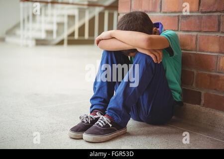 Sconvolto lonely bambino seduto da se stesso Foto Stock