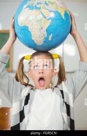 Carino pupilla globo di bilanciamento sulla testa in una classe Foto Stock