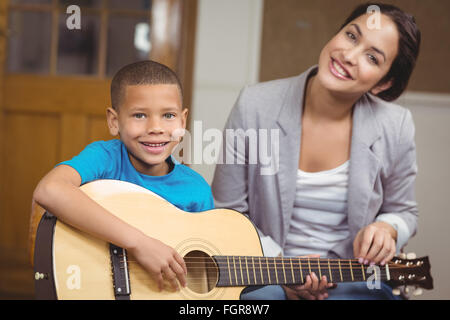 Piuttosto Docente dando lezioni di chitarra per alunno Foto Stock