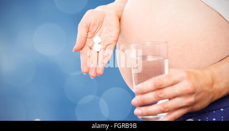 Immagine composita della donna incinta di prendere una compressa di vitamina Foto Stock