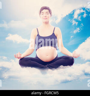 Immagine composita di pregnent donna seduta sul tappetino in lotus pongono su sfondo bianco Foto Stock