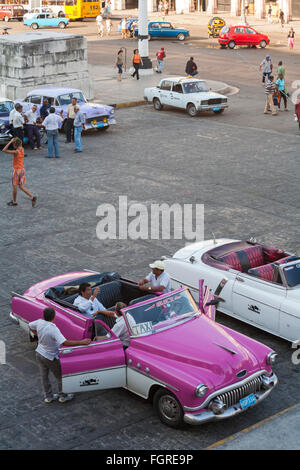 La vita quotidiana a Cuba - taxi e auto parcheggiata dal Capitolio Nacional, Havana, Cuba Foto Stock