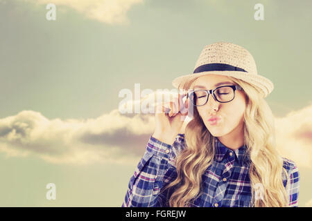 Immagine composita di una splendida bionda hipster di inviare aria kiss Foto Stock
