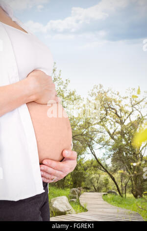 Immagine composita della vista laterale della donna incinta holding stomaco Foto Stock