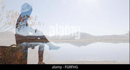 Immagine composita del hipster donna seduta sulla sua valigia Foto Stock