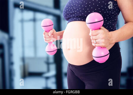 Immagine composita della sezione mediana della donna incinta il sollevamento pesi Foto Stock