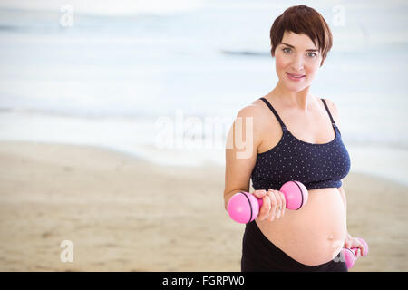 Immagine composita del ritratto di donna incinta il sollevamento pesi Foto Stock