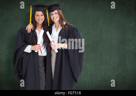 Immagine composita di due donne che abbraccia ogni altro dopo che si è laureato dall'università Foto Stock