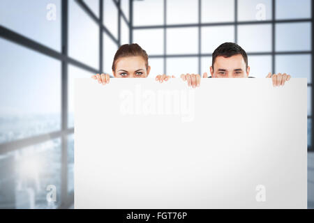 Immagine composita di partner commerciali di nascondersi dietro un segno Foto Stock