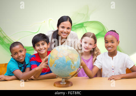 Immagine composita di graziosi gli alunni e gli insegnanti guardando il globo in biblioteca Foto Stock