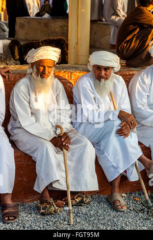 Anziani Omani uomini presso il venerdì il mercato del bestiame, Nizwa, Ad Dakhiliyah Regione, Oman Foto Stock