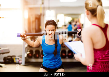 Donna esercizio in palestra, personal trainer, sul piano di appunti Foto Stock