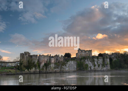 Chepstow Castle che si affaccia sul fiume Wye con tramonto spettacolare Foto Stock