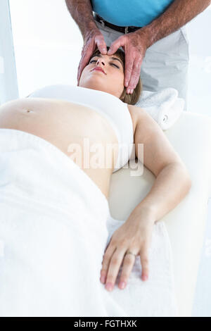 Calma la donna incinta ricevendo trattamento reiki Foto Stock