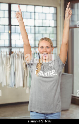 Donna con braccia alzate in piedi in ufficio Foto Stock