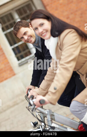 Coppia felice escursioni in bicicletta con la bici in città Foto Stock