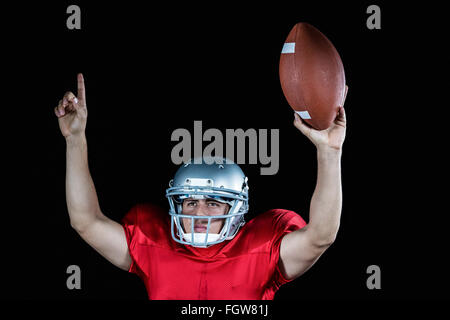 Giocatore di football americano a braccia alzate con sfera di trattenimento Foto Stock