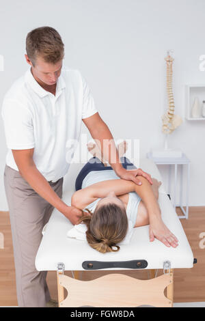 Fisioterapista facendo massaggio alla schiena al suo paziente Foto Stock