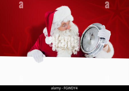 Immagine composita di santa tenendo un orologio e firmare Foto Stock