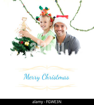 Immagine composita di felice padre e figlia decorare insieme l'albero di natale Foto Stock