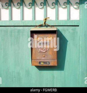 Vecchia cassetta postale su un cancello verde Foto Stock