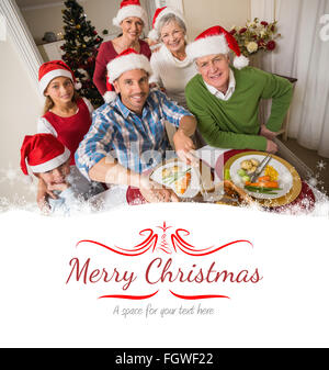 Immagine composita del padre in santa hat carving pollo a cena di natale Foto Stock