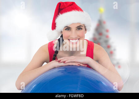 Immagine composita di festosa montare brunette appoggiata sulla palla ginnica Foto Stock