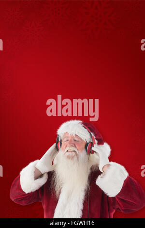 Immagine composita di santa claus gode di alcuni brani musicali Foto Stock