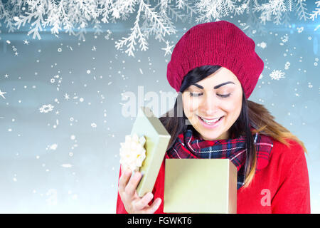 Immagine composita di felice brunette apertura regalo di natale Foto Stock