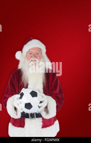 Immagine composita di santa detiene un classico football Foto Stock