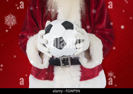 Immagine composita di santa detiene un classico football Foto Stock