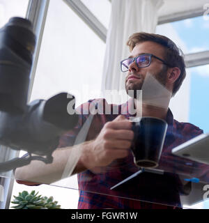 Giovane uomo di lavoro colpo da sotto un tavolo di vetro Foto Stock