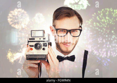 Immagine composita di geeky hipster tenendo una fotocamera retrò Foto Stock