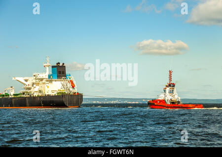 Rimorchiatore tirando la nave cisterna in mare al mattino. Foto Stock