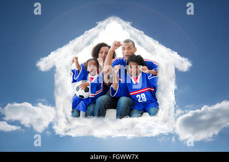 Immagine composita di una famiglia che celebra un obiettivo a casa Foto Stock