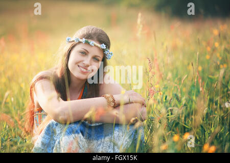 Sorridente donna romantica nel campo dei fiori . Hippie e gypsy dress Foto Stock