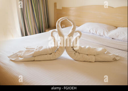 Design della camera da letto con cigni dalla decorazione asciugamano sul lettino Foto Stock