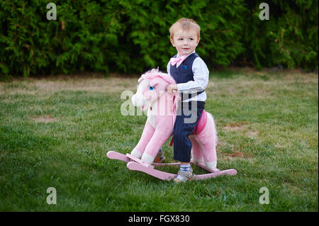 Baby boy giocando con il cavallo il parco giochi nel parco Foto Stock