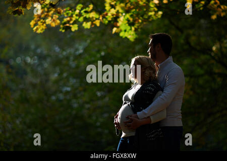 Il marito e la moglie incinta sono a piedi nel parco Foto Stock