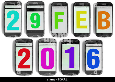29 feb scritto su schermi di smartphone fotografati contro uno sfondo bianco. Foto Stock