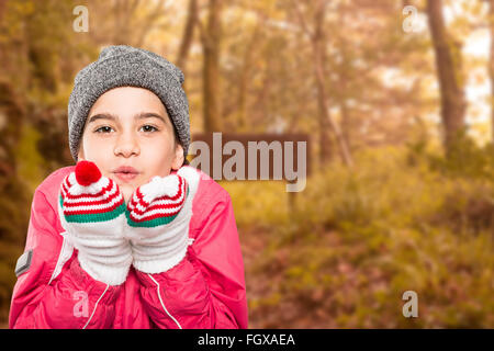 Immagine composita di avvolto bambina soffiare via le mani Foto Stock