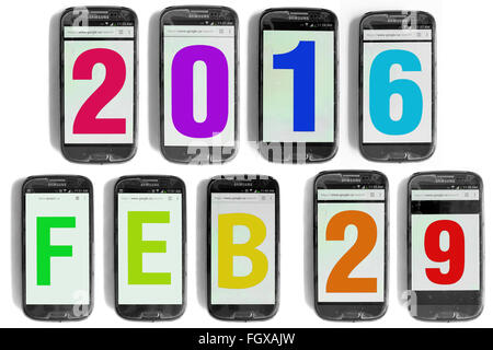 2016 29 Feb scritto su schermi di smartphone fotografati contro uno sfondo bianco. Foto Stock