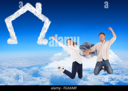 Immagine composita del giovane di salto e tenendo le mani Foto Stock