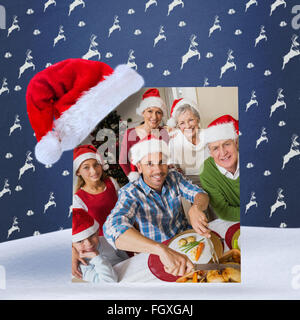 Immagine composita del padre in santa hat carving pollo a cena di natale Foto Stock