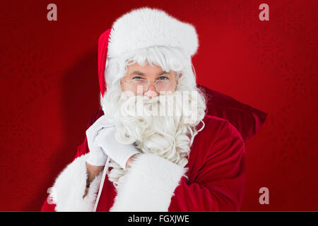 Immagine composita di felice santa claus tenendo il sacco Foto Stock