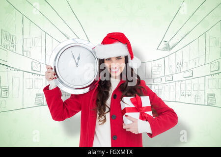 Immagine composita di festosa brunette holding di un orologio e di dono Foto Stock