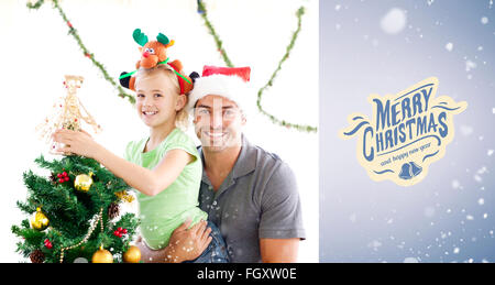 Immagine composita di felice padre e figlia decorare insieme l'albero di natale Foto Stock